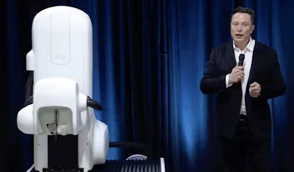 Elon Musk standing next to a surgical robot during his Neuralink presentation on 28 August 2020. (Neuralink/AFP via Getty Images)