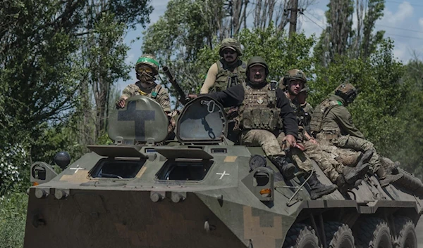 Ukrainian soldiers ride an APC on the front line near Bakhmut, in the Donetsk region, on June 5, 2023 (AP)