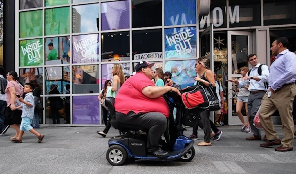 A man on an electric scooter makes his way with other pedestrians in New York on July 1, 2015 (AFP)