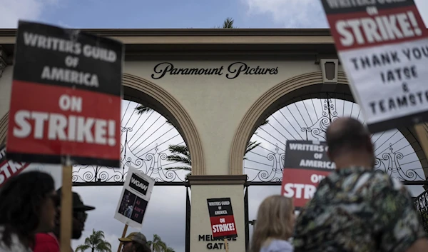 Demonstrators walk with signs during a rally outside the Paramount Picture Studio in Los Angeles, Sept. 21, 2023. (AP)