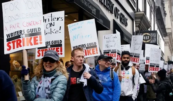 Demonstrators carry signs during a screenwriter’s strike in New York City on May 2, 2023. (AFP via Getty Images)