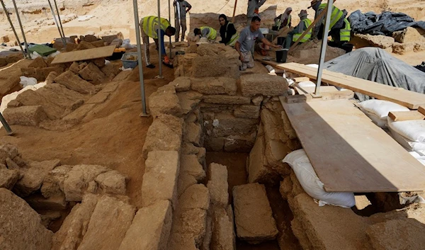 Palestinian archaeologists remove sand from graves at the Roman cemetery in Jebaliya northern Gaza Strip, Saturday, Sept. 23, 2023 (AP)