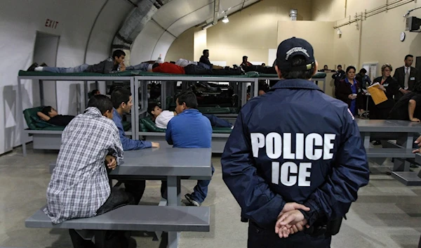 An Immigration and Customs Enforcement officer guards a group of 116 Salvadoran immigrants that wait to be deported at Willacy Detention Center in Raymondville, Texas. (AFP)