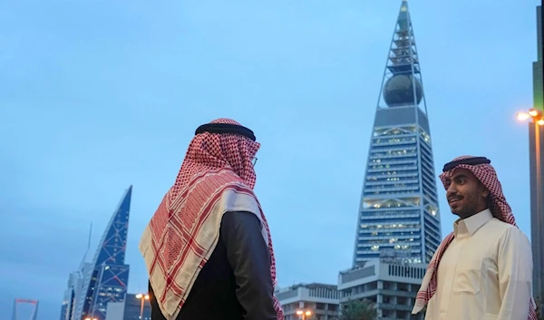 Saudis chat near the Faisaliah tower, one of the landmarks in Riyadh, Saudi Arabia, Thursday, Jan. 5, 2023. (AP)