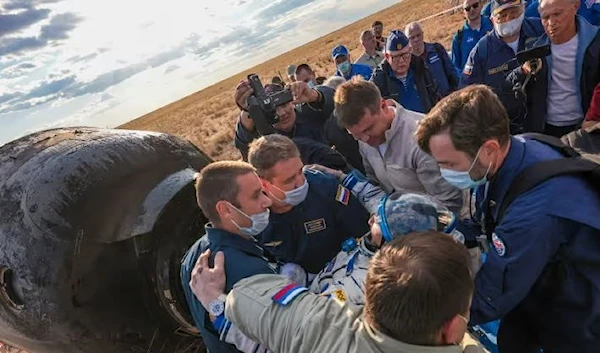 Rescue team members help Sergey Prokopyev to get out of the Soyuz capsule. (AP)