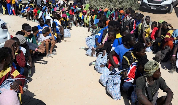 Migrants sit outside the Lampedusa's migrant reception center, Sicily, Thursday, Sept.14, 2023. (AP)