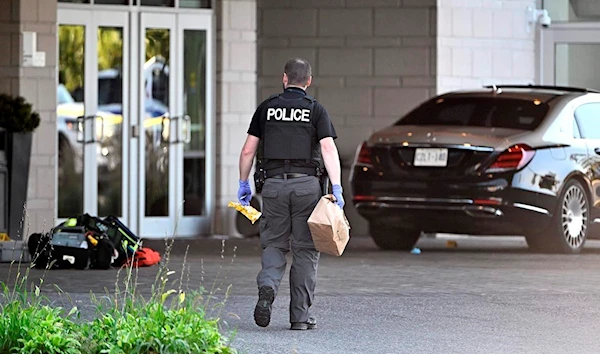 An Ottawa Police officer collects evidence after a Saturday night shooting at the Infinity Convention Centre that left two dead, in Ottawa, on Sunday, Sept. 3, 2023. (The Canadian Press)