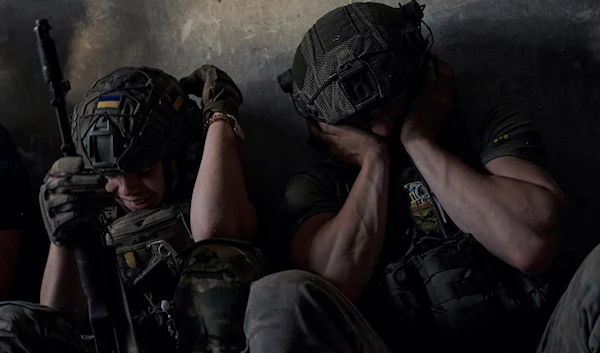 Ukrainian soldiers cover their ears to protect from the Russian tank shelling in a shelter on the frontline in the Zaporizhzhia regio, July 2, 2023 (AP)