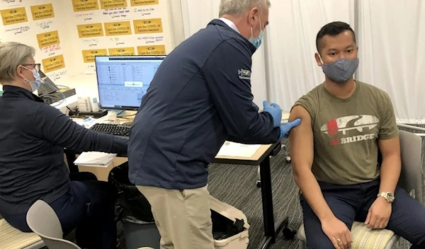 Brad Wenstrup administers a Covi-19 vaccine to Eli Livingston with the aid of a doctor in Norwood, Ohio, on March 28, 2021. (AP)