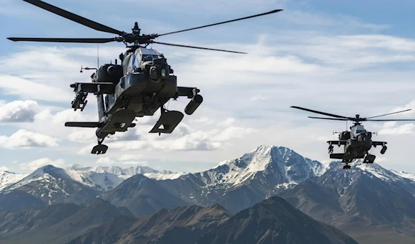 In this photo released by the US army, AH-64D Apache Longbow attack helicopters from the 1rst Attack Battalion, 25th Aviation Regiment, fly over a mountain range