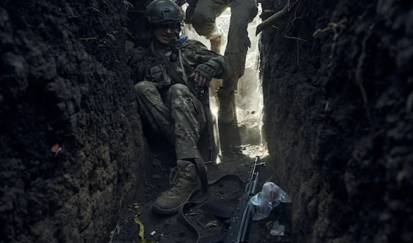 A soldier of Ukraine's 3rd Separate Assault Brigade jumps in a trench under the shelling near Bakhmut, the site of fierce battles with the Russian forces in the Donetsk region, Sept. 4, 2023 (AP)