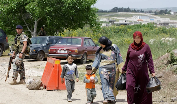 Syrian women and children walk after crossing the border into the northern town of Bukayaa, Lebanon, Friday, April 29, 2011 (AP Photo/Bilal Hussein)