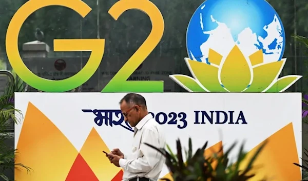 A man is seen walking past a G20 logo in New Delhi, India. (AFP)