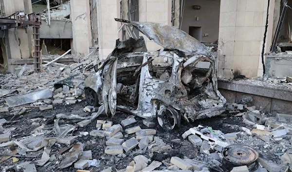 A burnt car is seen near an administrative building after shelling in the DPR, Russia, Oct. 16, 2022. (AP)