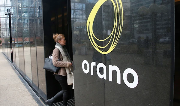 A woman enters the Areva Tower, showing the Orano logo, Paris, Tuesday, Jan. 23, 2018