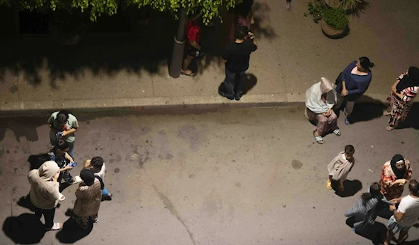 People take shelter and check for news on their mobile phones after an earthquake in Rabat, Morocco, Friday, Sept.8, 2023. (AP)