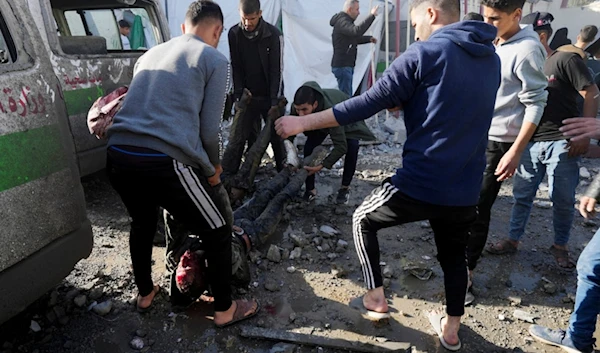 Palestinians remove people killed on the Al-Aqsa Hospital grounds after an Israeli strike hit a building next to it, in Deir al Balah, Gaza Strip, on Wednesday, Jan 10, 2023. (AP Photo/Adel Hana)