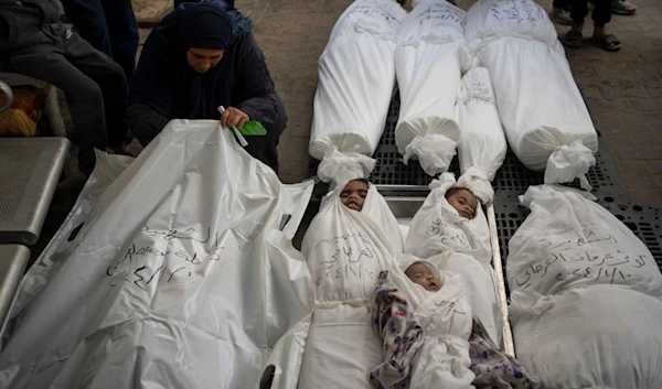 Palestinians mourn their relatives, including kids killed in the Israeli bombardment of the Gaza Strip, outside a morgue in Rafah, southern Gaza, Thursday, Jan. 11, 2024. (AP Photo/Fatima Shbair)