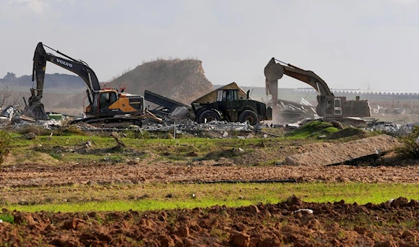 Israeli excavator, bulldozers, and cranes demolish the remains of "Karni" commercial border crossing separating Gaza from mainland Occupied Palestine, east of Gaza City, Tuesday, Dec. 6, 2022 (AP)