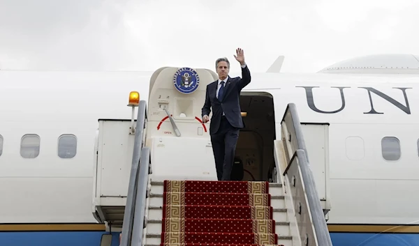 Blinken waves as he boards his plane to return to Washington following his Middle East Tour in Egypt, Jan. 11 2024. (AP)