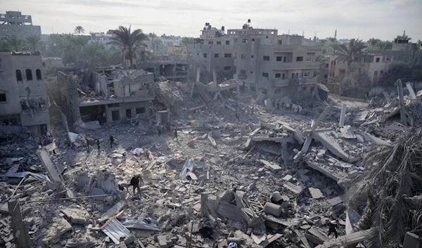 Palestinians look at destruction by the Israeli bombardment of the Gaza Strip, in Deir al Balah, occupied Palestine, Wednesday, Nov. 22, 2023. (AP)