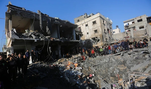 Palestinians watch the destruction after the Israeli bombardment of the Gaza Strip outside a morgue in Rafah, Tuesday, Dec. 19, 2023. (AP)