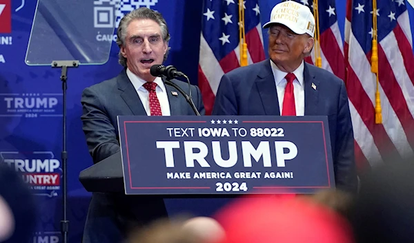 Republican presidential candidate former President Donald Trump listens as North Dakota Gov. Doug Burgum speaks at a rally at Simpson College in Indianola, Iowa, Jan. 14, 2024. (AP )