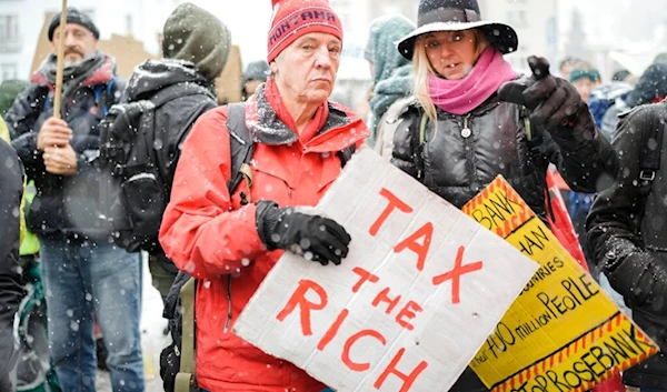 People attend a demostration against the annual meeting of the World Economic Forum in Davos, Switzerland Sunday, Jan. 15, 2023 (AP)