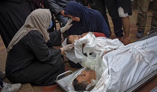 A Palestinian woman mourns her child and her husband killed in an IOF bombing of the Gaza Strip, outside the hospital in Khan Younis, Tuesday Dec. 5, 2023.