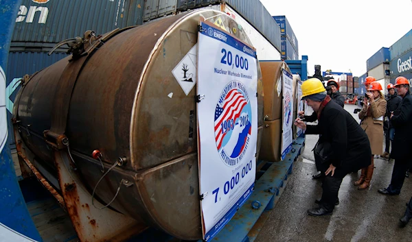 Representatives of participating companies sign containers with uranium to be used as fuel for nuclear reactors, prior to loading them aboard Atlantic Navigator ship, on a port in St. Petersburg, Russia, Thursday, Nov. 14, 2013