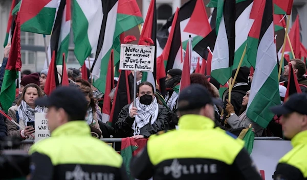 Protesters carry flags and banners outside the International Court of Justice in The Hague, Netherlands, Friday, Jan. 12, 2024. (AP)