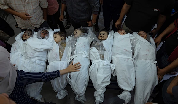 Palestinians stand around the bodies of their children killed by Israeli bombardment of the Gaza Strip in a morgue in Khan Younis, Thursday, Oct. 19, 2023. (AP)