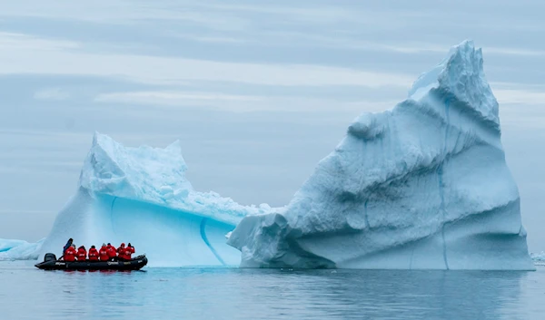 A group from the Poseidon Expeditions looks over an iceberg in the Scoresby Sund, Thursday, Sept. 7, 2023, in Greenland(AP)