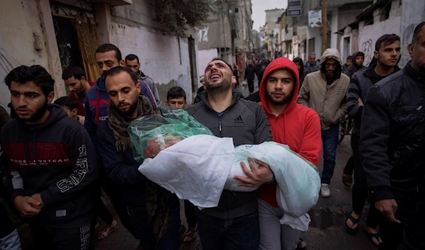 Mohammad Shouman carries the body of his daughter, Masa, who was killed in an Israeli bombardment of the Gaza Strip, during her funeral in Rafah, southern Gaza, Wednesday, Jan. 17, 2024. (AP)