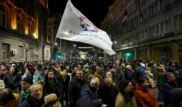 A protester waves a flag that reads: 'EUROMAIDAN Serbia' during a rally in downtown Belgrade, Serbia, Tuesday, Jan. 16, 2024. (AP)