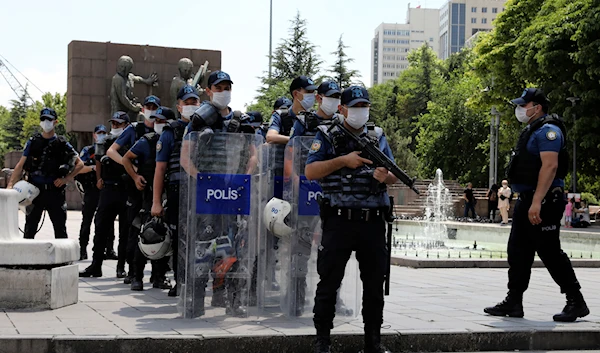 Riot police officers stand as lawyers march to the city's main courthouse as the heads of Turkish lawyers' associations wait for a second day to enter the parliament, in Ankara, Turkey, Friday, July 3, 2020. (AP)