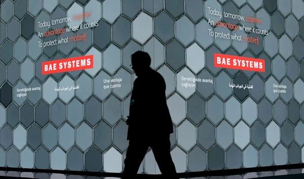 A man walks past a screen in the BAE Systems chalet at the Farnborough Airshow in Farnborough, England, on July 16, 2018 (AP)