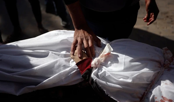 A Palestinian man mourns over the body of a child killed in the Israeli bombardment of the Gaza Strip, at Nasser hospital in Khan Younis, Monday, Jan. 22, 2024. (AP Photo/Mohammed Dahman)