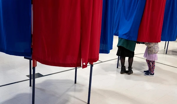 Kara Simard, left, votes with her daughter, Violet, 5, in the New Hampshire presidential primary at a polling site in Manchester, N.H., Tuesday, Jan. 23, 2024. (AP)