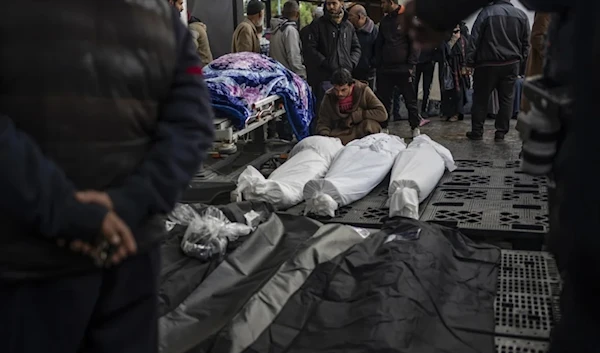 Palestinians gather around the bodies of their family members who were killed in the Israeli ground offensive and bombardment of Khan Younis, outside a morgue in nearby Rafah, in southern Gaza, on January 24. (AP)