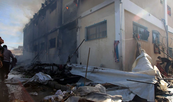 Palestinians try to extinguish a fire at a building of an UNRWA vocational training center which displaced people use as a shelter, after being targeted by Israeli tank shill in Khan Younis, southern Gaza Strip, Wednesday, Jan. 24, 2024. (AP)