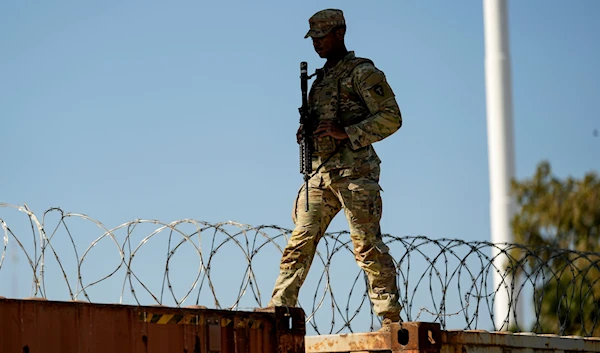 A guardsman walks over rail cars with Concertina wire along the Texas-Mexico border, January 3, 2024, in Eagle Pass, Texas (AP)