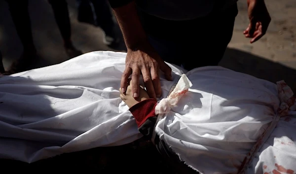 A Palestinian man mourns over the body of a child killed in the Israeli bombardment of the Gaza Strip, at Nasser hospital in Khan Younis, Monday, Jan. 22, 2024. (AP)