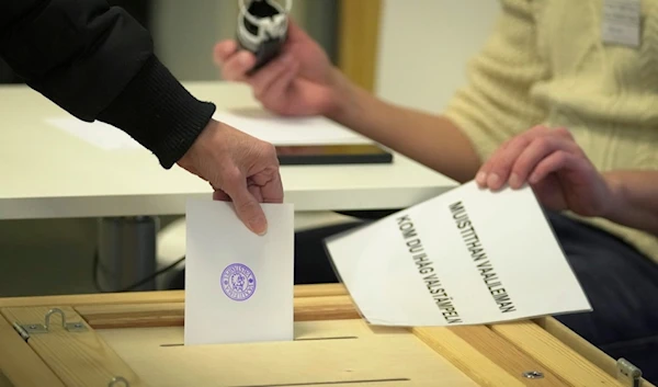 A woman casts her ballot at a polling station during presidential election in Helsinki, Finland, Sunday, Jan. 28, 2024. (AP)