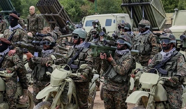 Hezbollah fighters manning RPGS astride bikes manning RPG behind them sits rocket launchers during military drills (social media)