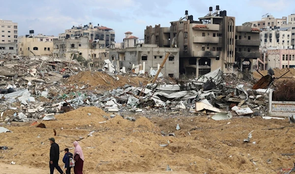 Palestinians walk past the building destroyed in the Israeli Bombardment of the Gaza Strip in Gaza City on Wednesday, Jan. 3, 2024. (AP Photo/Mohammed Hajjar)