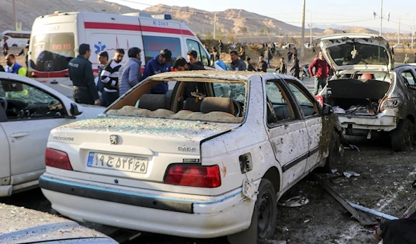 People stand next to destroyed cars after an explosion in Kerman, Iran, Wednesday, Jan 3, 2024. (AP)