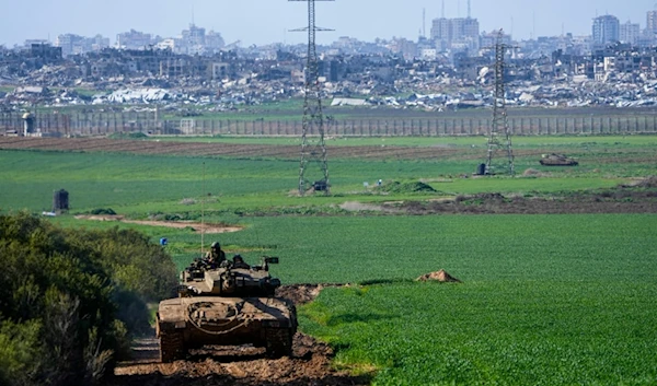 An Israeli tank drives to a position on the border with the Gaza Strip, as seen from southern occupied Palestine, Tuesday, Jan. 30, 2024. (AP Photo/Ariel Schalit)