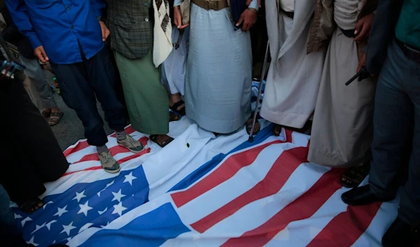 Yemenis trample on US and Israeli flags during a rally against the US-sponsored Saudi-led coalition in Sanaa, Yemen, Monday, Nov. 22, 2021 (AP)