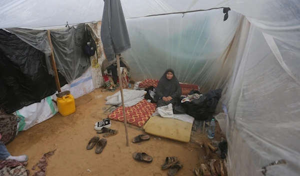 A Palestinian woman displaced by the Israeli bombardment sits in a makeshift tent in Rafah, Gaza Strip, Tuesday, Jan. 2, 2023. (AP Photo/Hatem Ali)